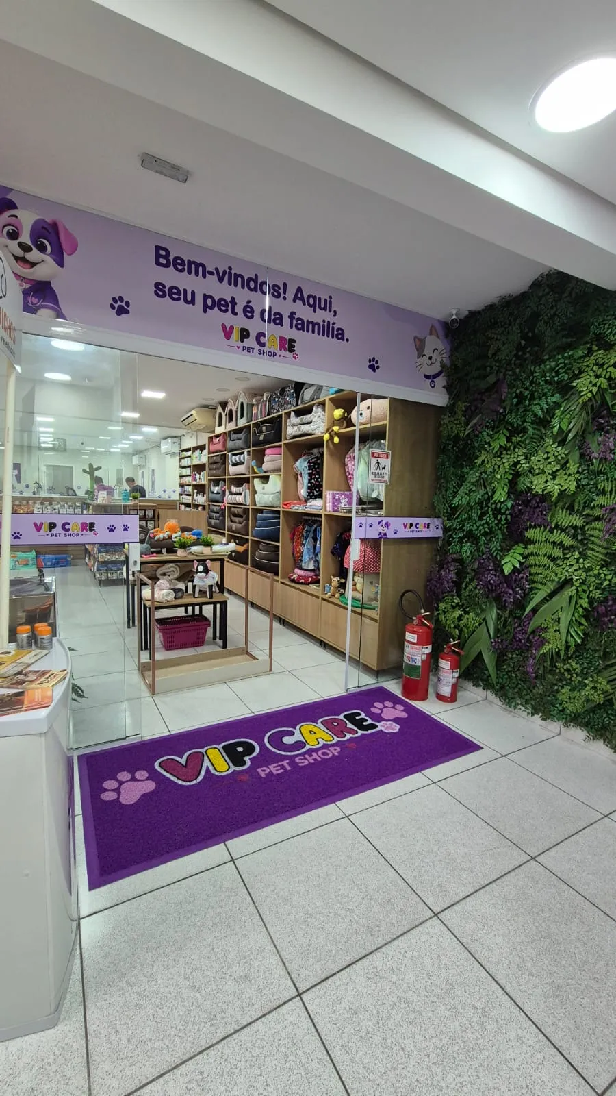Entrada da loja VIP Care Pet Shop com tapete roxo e prateleiras de produtos